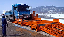進行方向にしたがい、車両を装置にゆっくり乗せる。